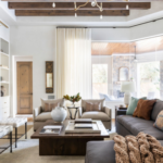 How can lowering the height of artwork or photos make a room feel more human and relaxed